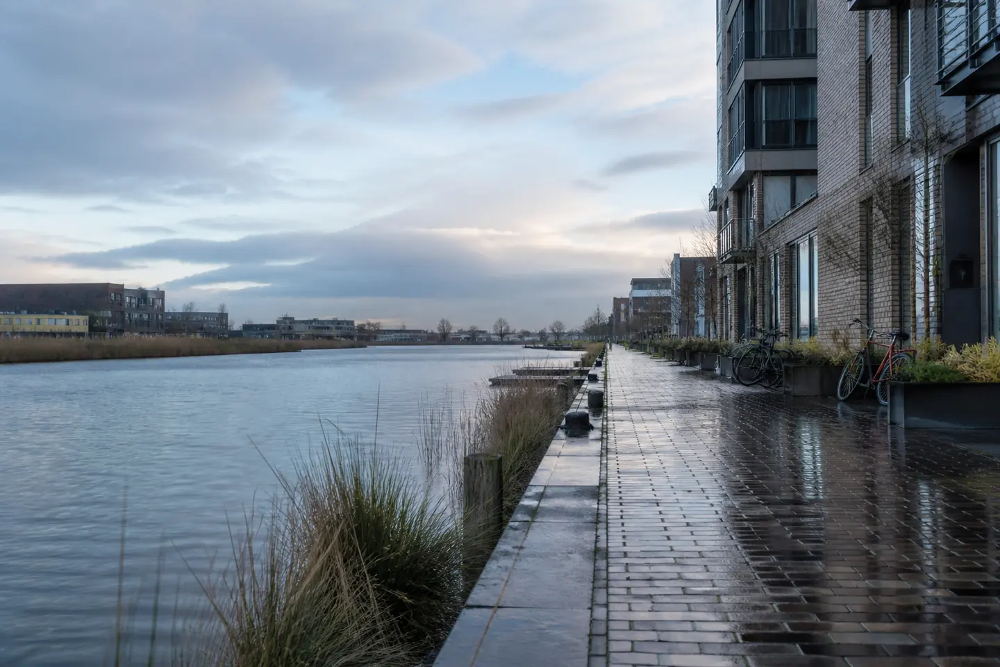 Nederlands waterfront met hedendaagse architectuur en fietsen op de achtergrond